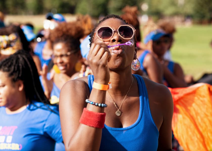 GirlTrek founder Morgan blowing bubbles during an event in the park outside