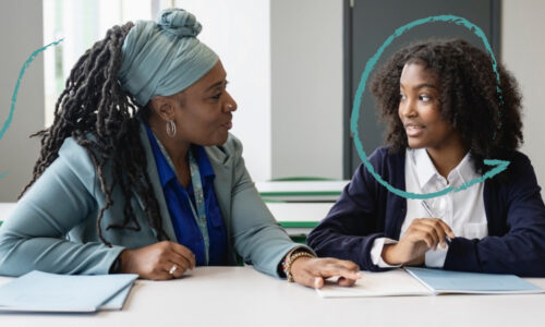 Teacher and girl in classroom together at a desk
